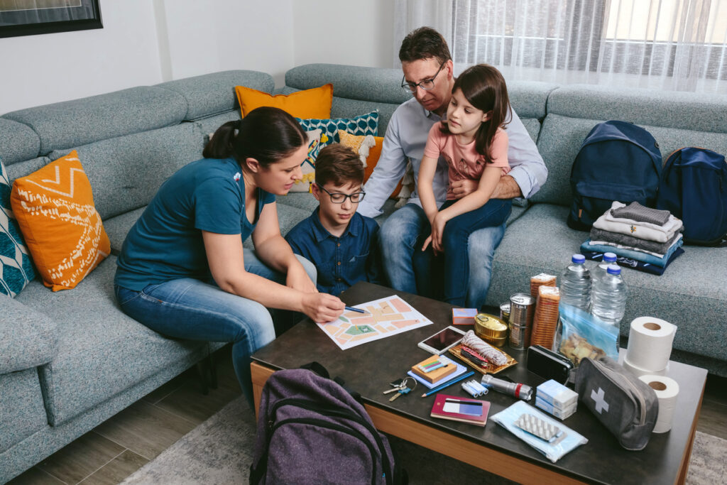 A family sitting on a couch looking at an emergency evaculation plan