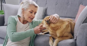 Woman comforting her dog while concerned he may be experiencing pain